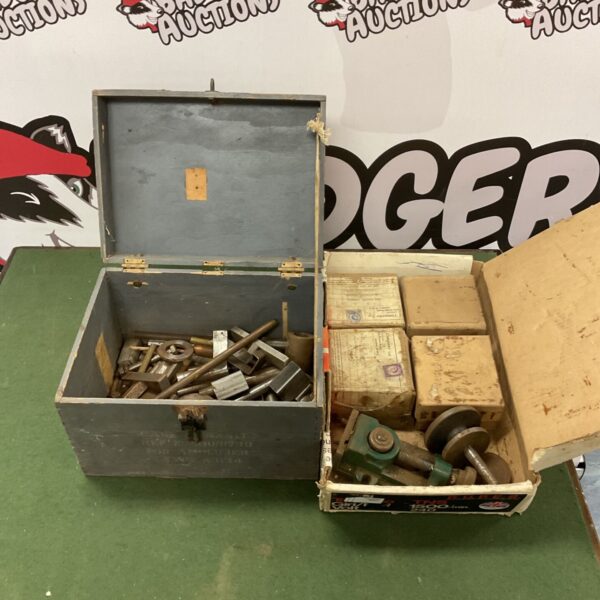 Vintage tool case with metal cylinders and hand vice inside.