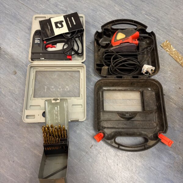 Vintage tool lot featuring a Black & Decker sander, staple gun, and drill bits.
