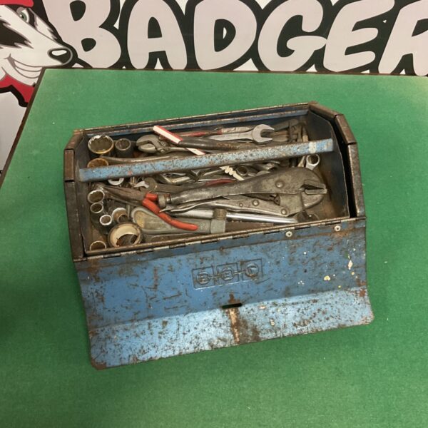 Vintage blue metal toolbox filled with wrenches and spanners.