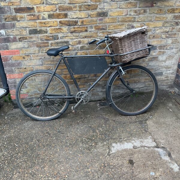 Vintage tradesman's bicycle with a woven basket attached.