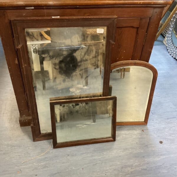 Ornate vintage wall mirror with a dark wooden frame.