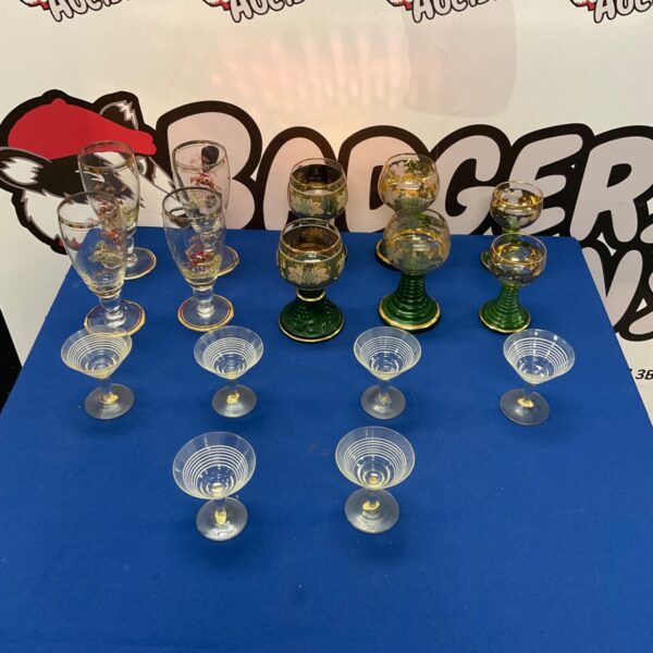 Vintage wine goblets with gold rims and etched designs on display.