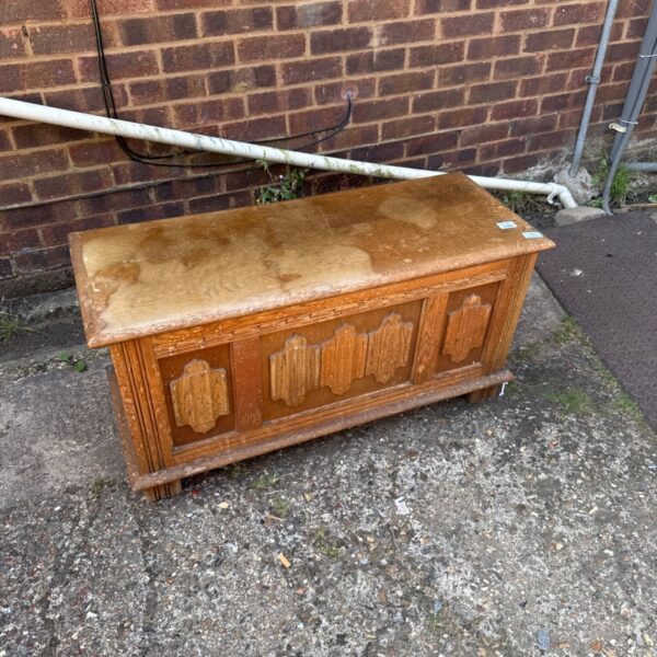 Vintage wooden blanket box with water stains on top.