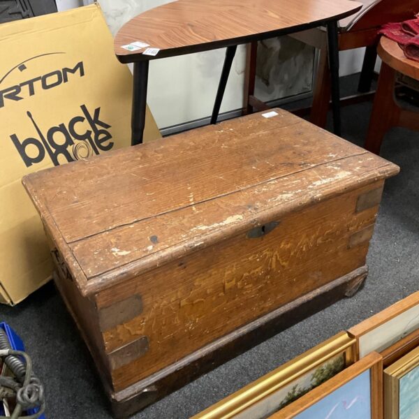 Front view of a vintage wooden chest with brass fittings.