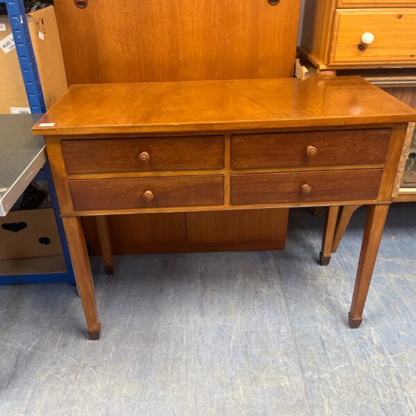 Vintage wooden desk with four drawers and turned knobs.