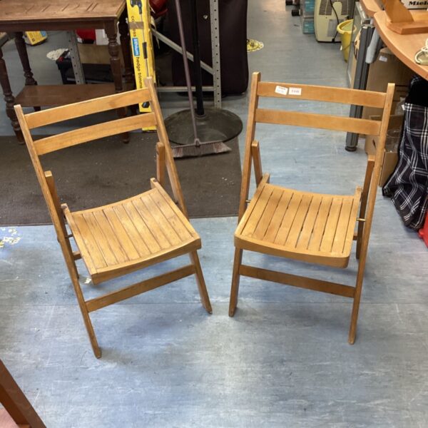 Vintage wooden folding chair with slatted seat, rustic style.