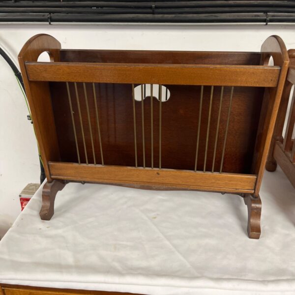 Vintage wooden magazine rack with brass wire dividers for storage.