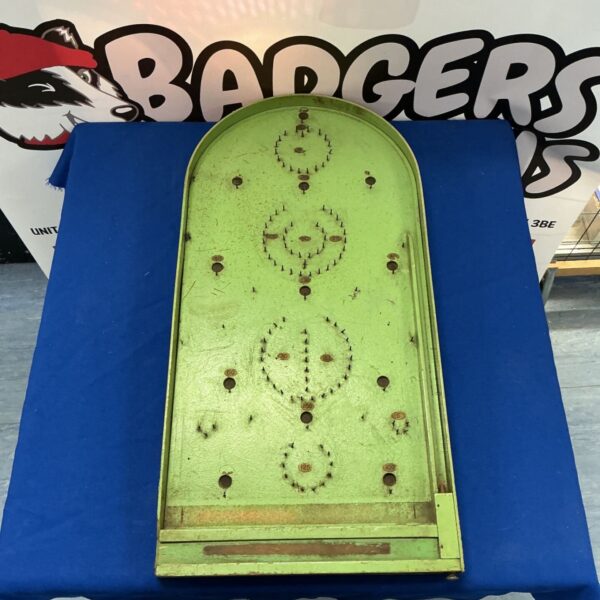 Vintage wooden pinball board with faded paint and wear.