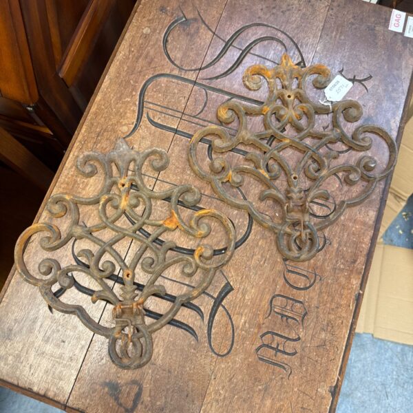 Vintage wrought iron pot hanger with scrolling design for rustic kitchen decor.