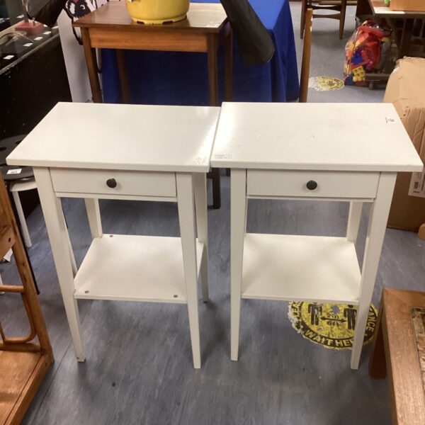 Pair of white side tables with drawer and shelf.