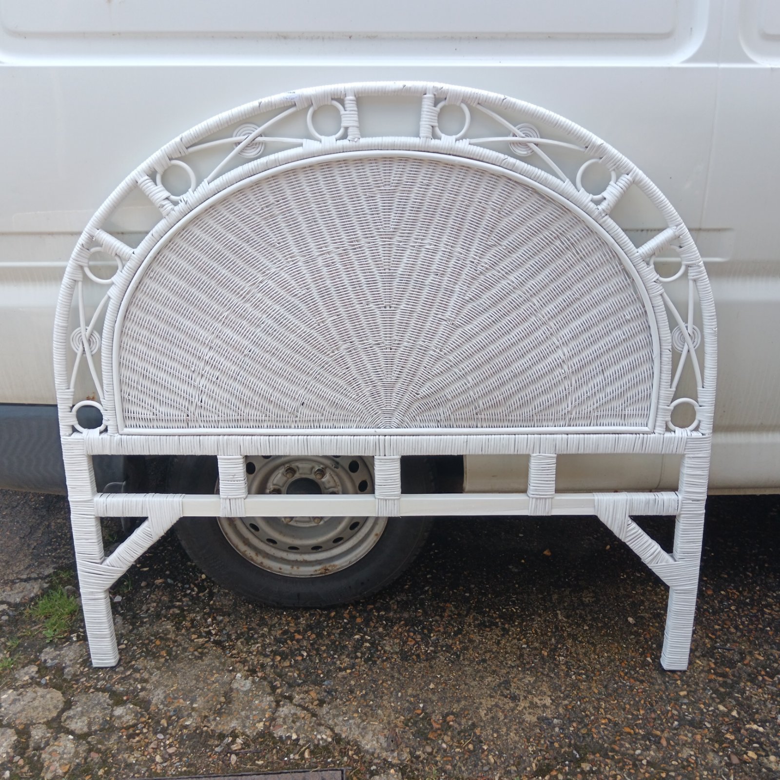 White wicker double bed headboard with arched design.