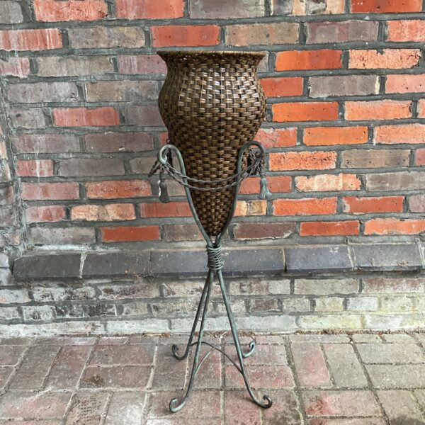 Vintage wicker amphora vase on bronze metal tripod stand.