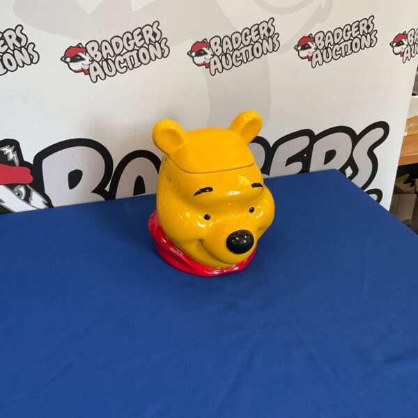 Front view of a yellow Winnie the Pooh cookie jar.