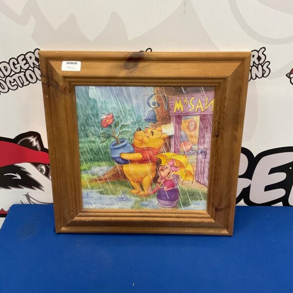 Framed Winnie the Pooh print for children's room decor.
