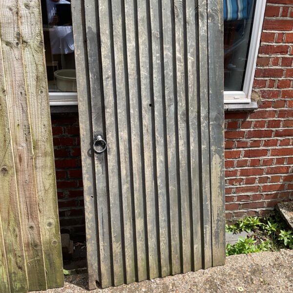 Rustic wooden garden gate with weathered planks and a central handle.