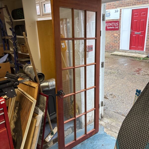 Vintage wooden door with glass panels, ideal for restoration.