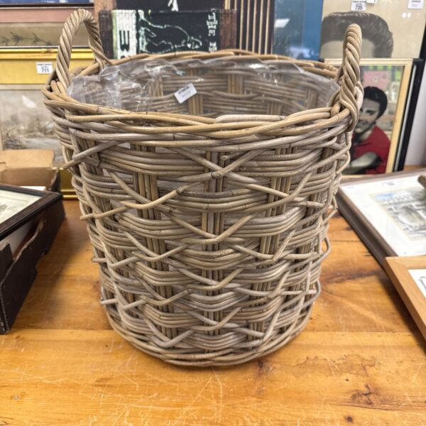 Tall woven stick basket for rustic farmhouse storage.