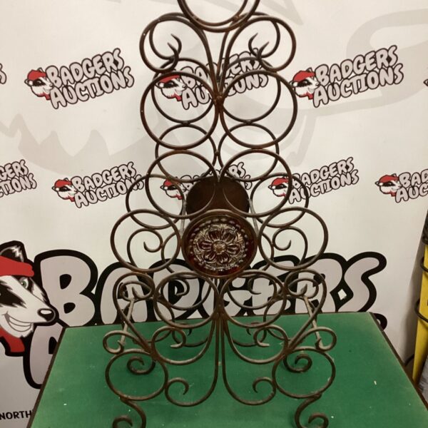 Vintage wrought iron wine rack with circular bottle holders.