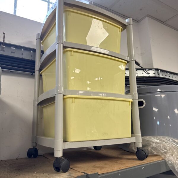 Yellow plastic three-drawer wheeled storage cabinet for home organization.