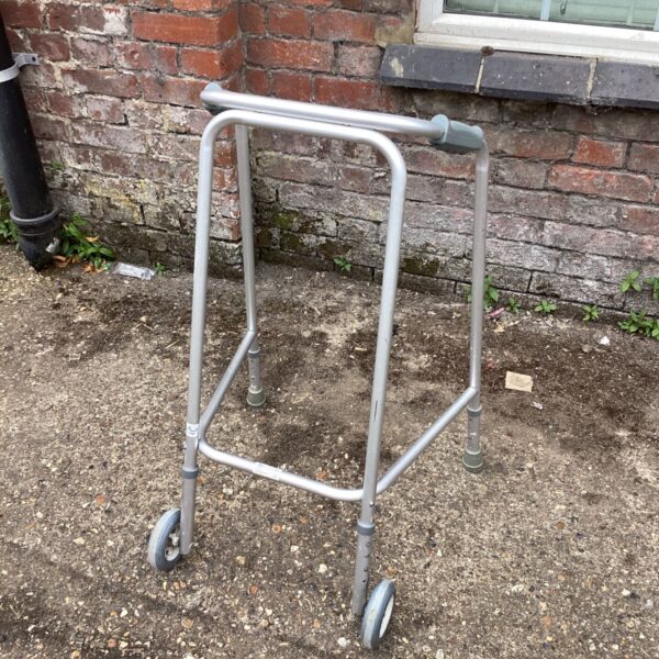 Silver aluminum walking frame with wheels for mobility support.