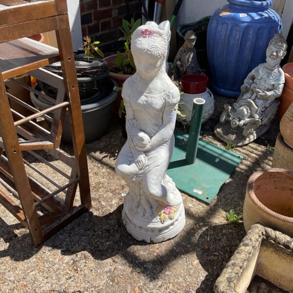 Vintage angel garden figurine in a garden setting.