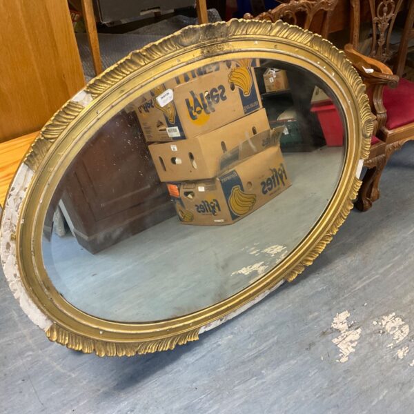 Antique bevel edge mirror with ornate gilded frame for restoration.