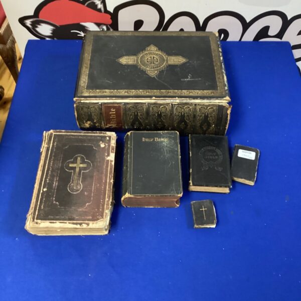 Six antique bibles stacked together, vintage religious texts.