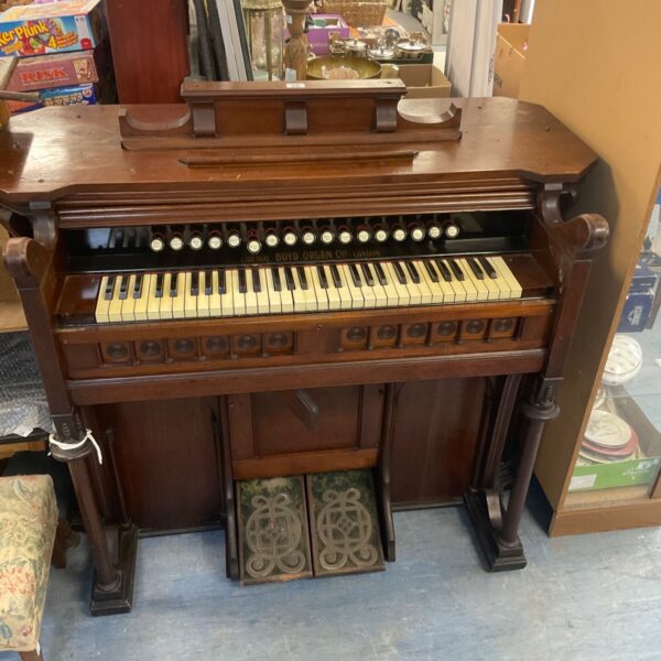 Front view of antique Boyd pump organ with keyboard and bellows.