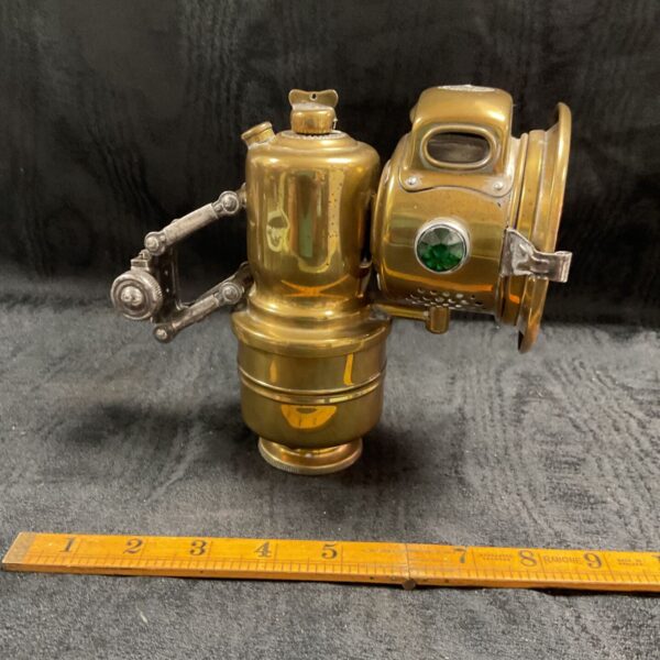 Antique brass carbide bicycle lamp side view.
