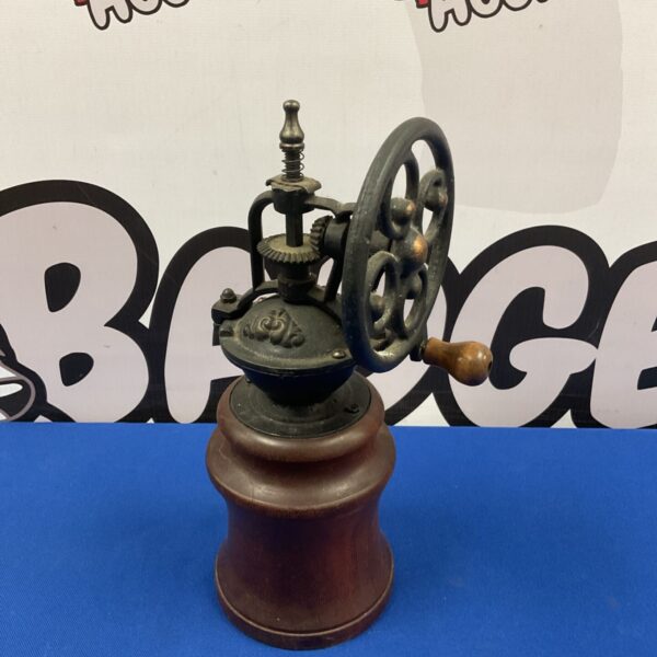 Antique cast iron coffee mill with wooden base.