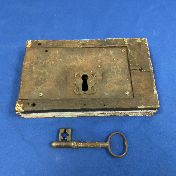 Antique door lock with key, vintage iron hardware.