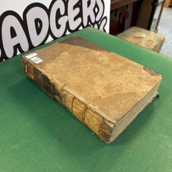 Antique family bible with worn leather cover on green surface.