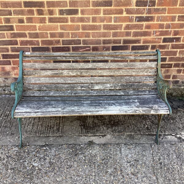 Antique garden bench with wrought iron ends and weathered wood.