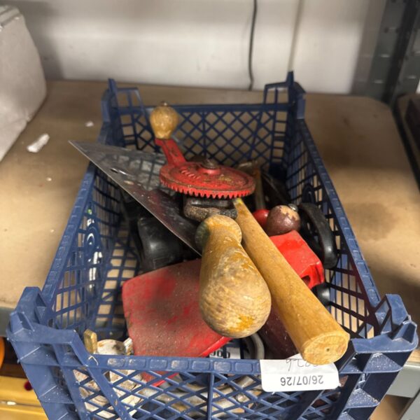 Antique hand tools lot featuring a hand drill and axe head.