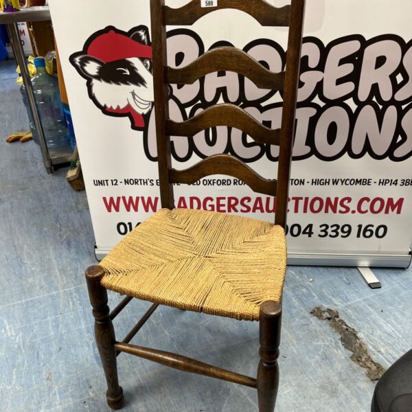 Antique ladder back chair with woven rush seat and turned legs.