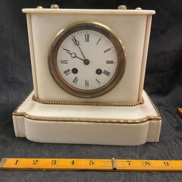 Ornate antique marble mantle clock with silver medal detail.