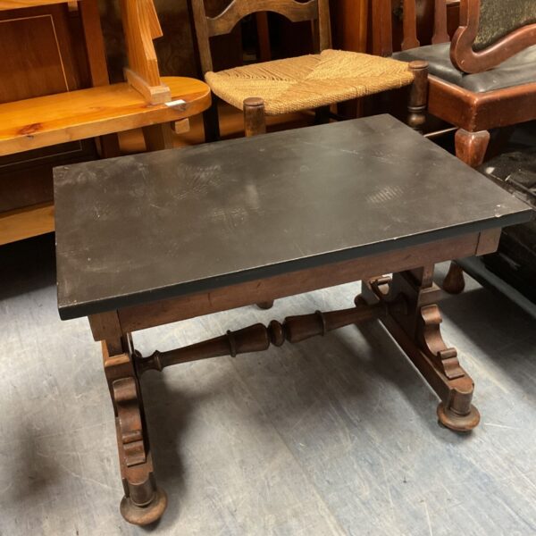 Antique oak side table with carved legs and caster wheels.