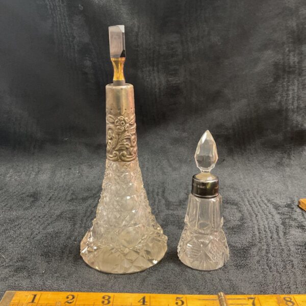 Antique silver scent bottles with hallmarked silver collars.