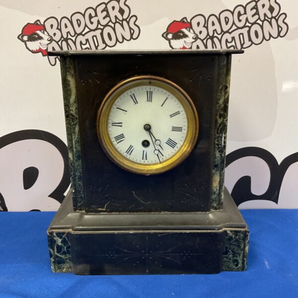 Antique slate mantle clock with marble detail and Roman numerals.