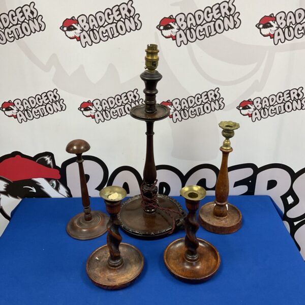 Antique wooden candlesticks and a vintage table lamp on display.