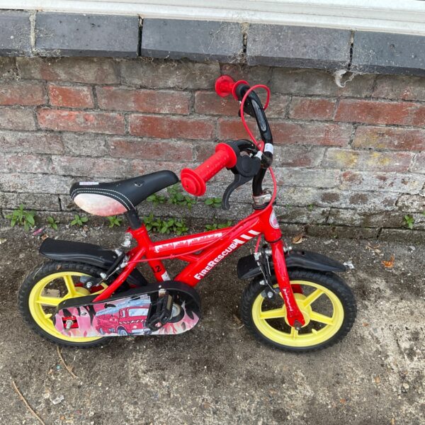 Red Apollo Firechief 12 inch kids bike with stabilisers.