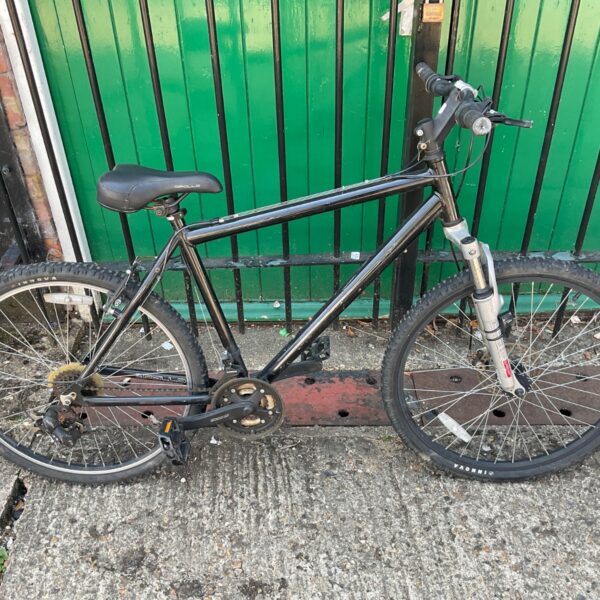 Black Apollo mountain bike with front suspension and geared wheels.