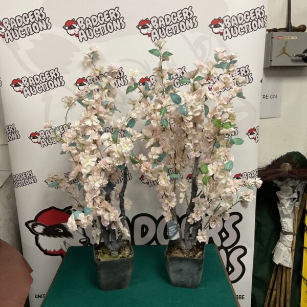 Two artificial blossom trees in planters, ideal for home decor.