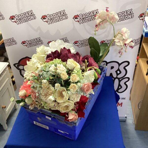 Artificial flower arrangement in a blue crate, featuring white roses.