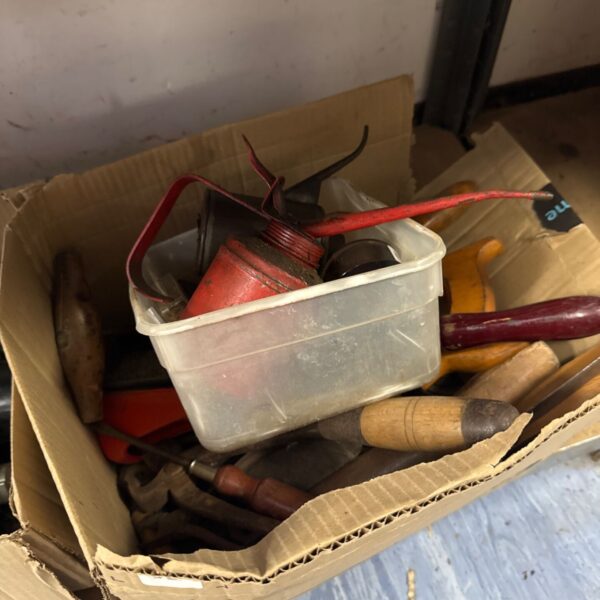 Box of assorted vintage hand tools and oil cans.