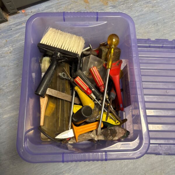 Assorted hand tools in a box, including screwdrivers and chisels.