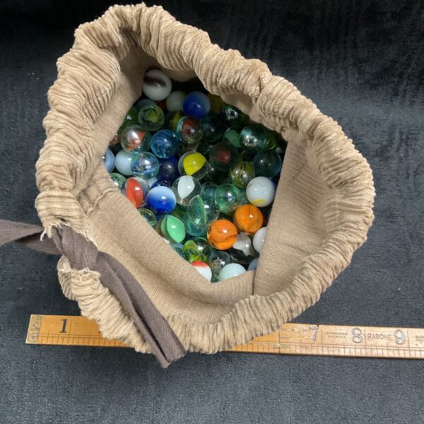Large lot of assorted vintage glass marbles in a burlap bag.