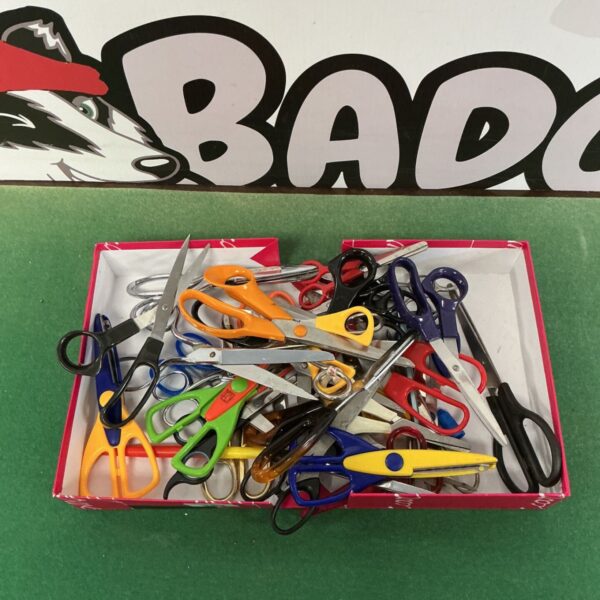A box filled with a large assortment of colourful scissors.