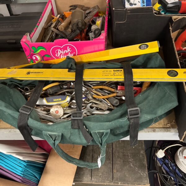 Assorted tool lot in a green bag, ready for DIY projects.