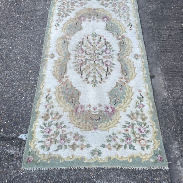 Pastel Aubusson rug with floral medallion design in green and cream.